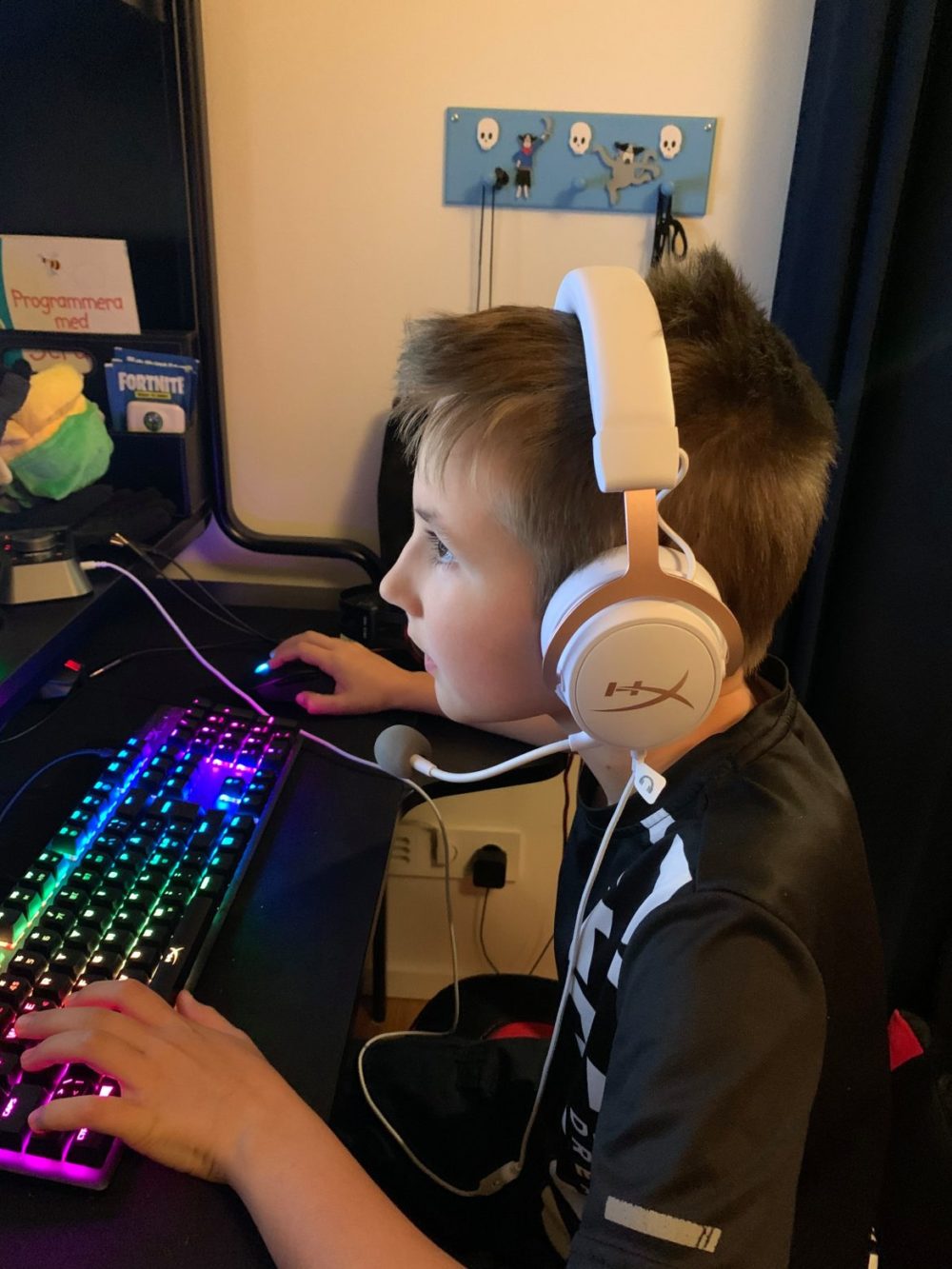 Boy playing PC with HyperX Cloud Mix Rose Gold